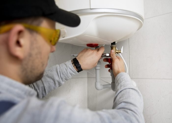 worker-repairing-water-heater worker-repairing-water-heater